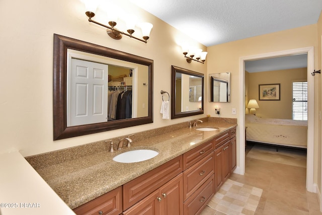 bathroom featuring vanity, tile patterned floors, and a textured ceiling