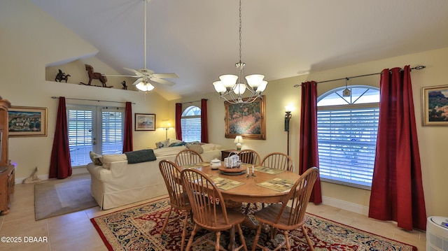 tiled dining area featuring ceiling fan with notable chandelier and lofted ceiling