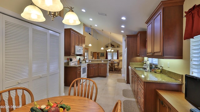 kitchen with an inviting chandelier, kitchen peninsula, hanging light fixtures, and white appliances