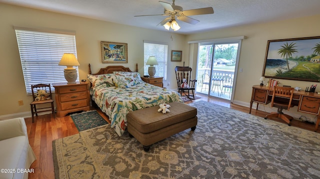 bedroom featuring access to outside, ceiling fan, a textured ceiling, and hardwood / wood-style flooring