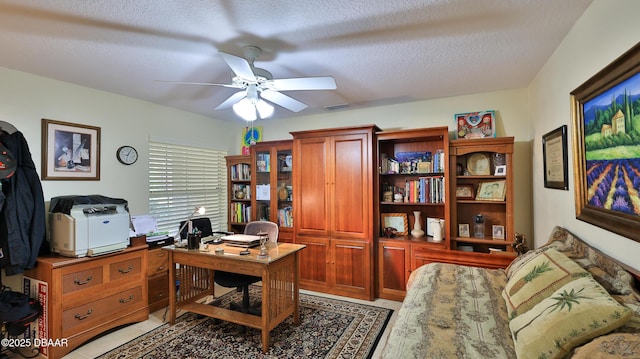 tiled office space featuring ceiling fan and a textured ceiling