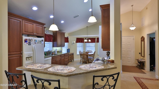 kitchen featuring a breakfast bar, pendant lighting, white appliances, and kitchen peninsula