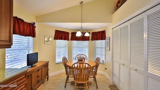 dining area with vaulted ceiling, a chandelier, and light carpet