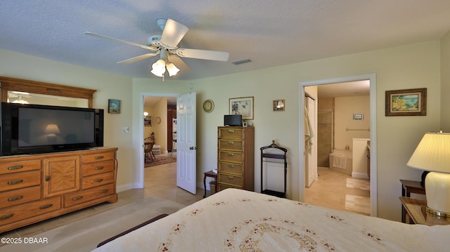 tiled bedroom with ceiling fan, a textured ceiling, and ensuite bathroom