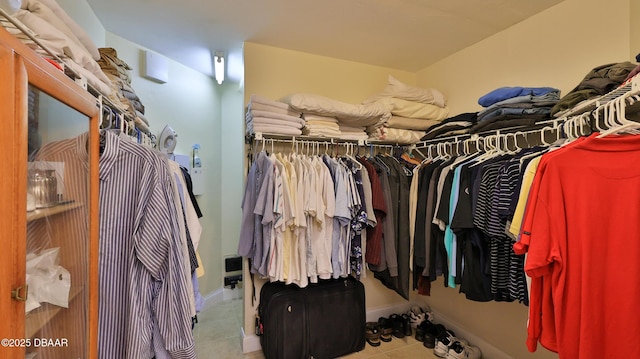 walk in closet with light tile patterned floors