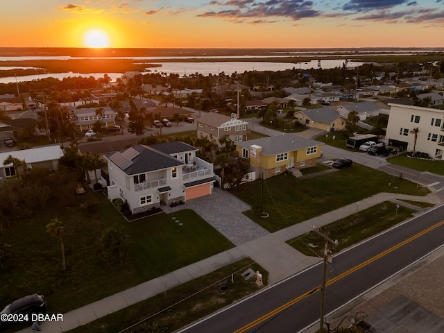 aerial view at dusk featuring a water view