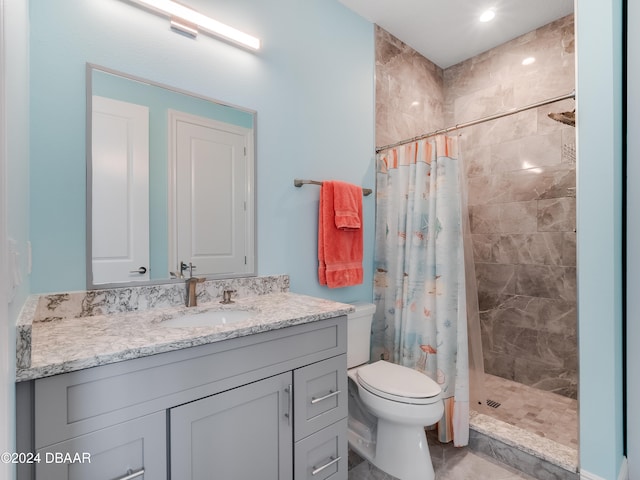 bathroom with toilet, vanity, and a shower with shower curtain