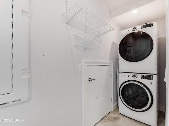 laundry room with stacked washer and dryer and an inviting chandelier