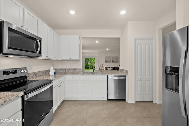 kitchen featuring white cabinetry, appliances with stainless steel finishes, sink, and light stone counters