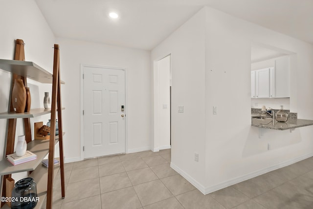 foyer featuring sink and light tile patterned floors