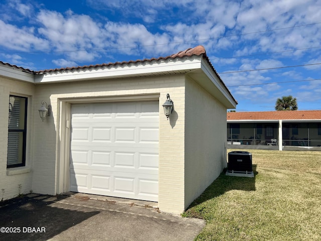 garage with a lawn and central air condition unit