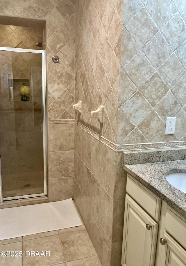 bathroom with tile patterned floors, vanity, and an enclosed shower