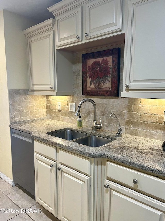 kitchen featuring sink, light tile patterned floors, dishwasher, light stone countertops, and decorative backsplash