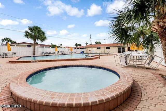 view of swimming pool with a jacuzzi and a patio area