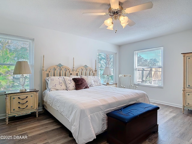 bedroom featuring a textured ceiling, ceiling fan, wood finished floors, and baseboards