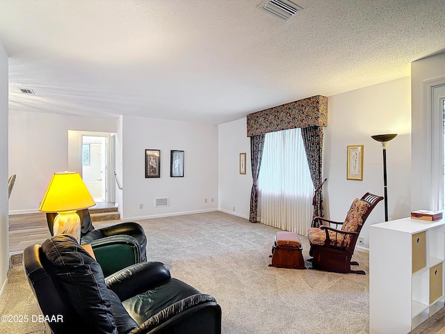 living room featuring a textured ceiling, light carpet, and visible vents