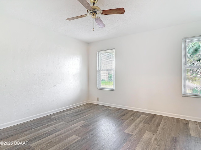 empty room featuring ceiling fan, baseboards, a textured ceiling, and wood finished floors