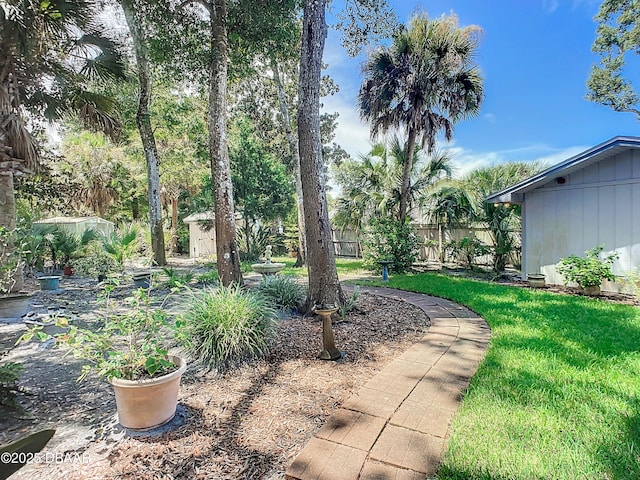 view of yard with fence and an outdoor structure