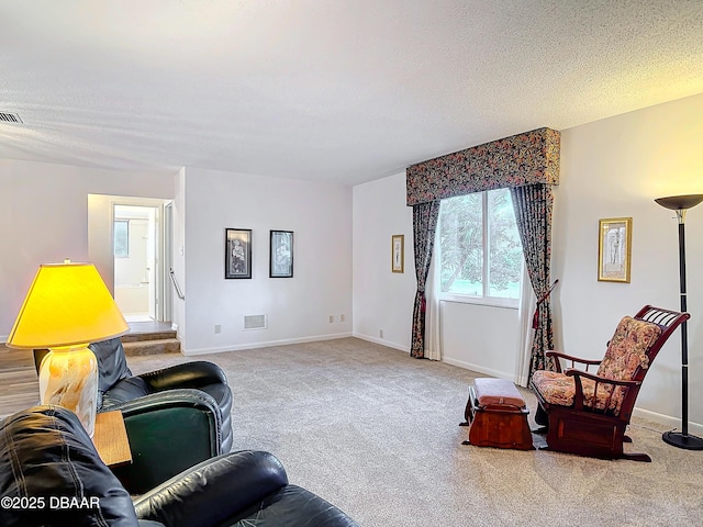 living room with baseboards, visible vents, light carpet, and a textured ceiling