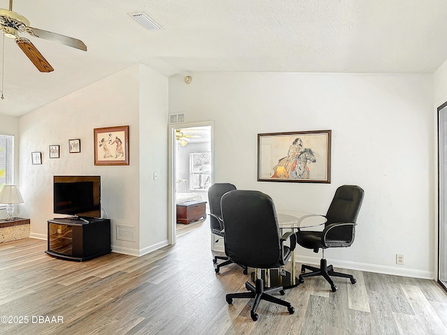 office area with visible vents, vaulted ceiling, and wood finished floors