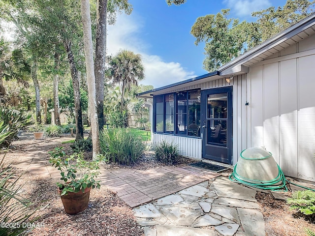 doorway to property with board and batten siding and a patio area