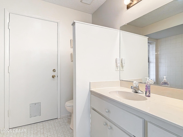 bathroom featuring toilet, visible vents, a textured ceiling, and vanity