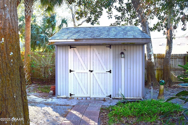 view of shed featuring fence