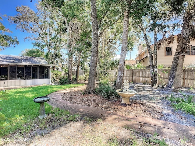 view of yard featuring a sunroom and fence