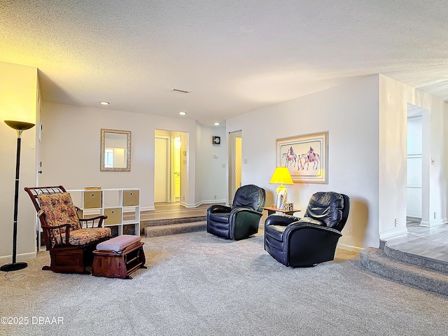 sitting room featuring a textured ceiling, carpet, visible vents, and baseboards