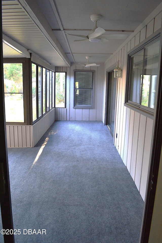 unfurnished sunroom featuring a ceiling fan