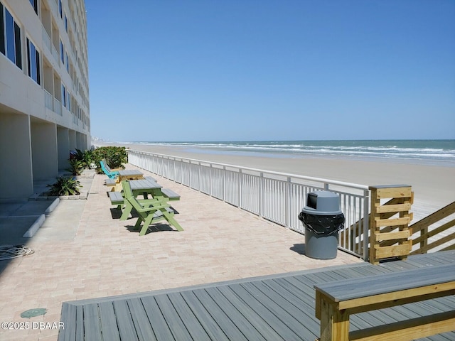 deck with a beach view and a water view