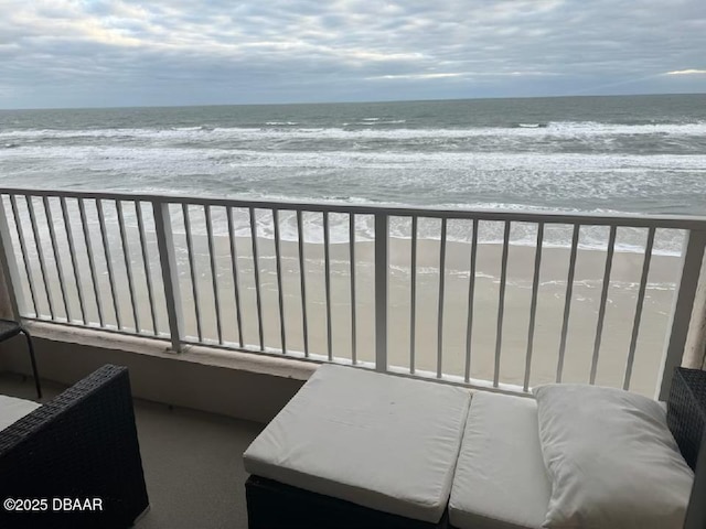 balcony featuring a view of the beach and a water view