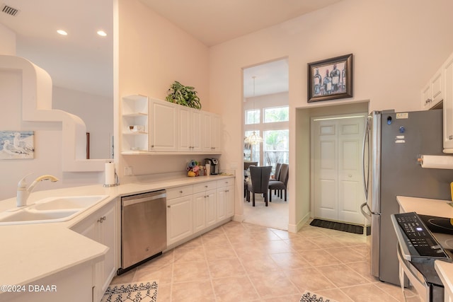 kitchen featuring white cabinetry, sink, light tile patterned floors, and stainless steel appliances