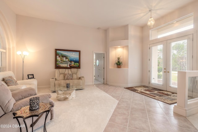 tiled living room with french doors and an inviting chandelier