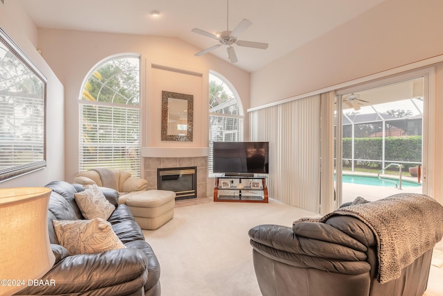 carpeted living room featuring a fireplace, vaulted ceiling, and ceiling fan