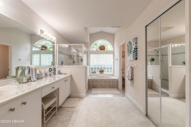 bathroom featuring a textured ceiling, vanity, plus walk in shower, and vaulted ceiling