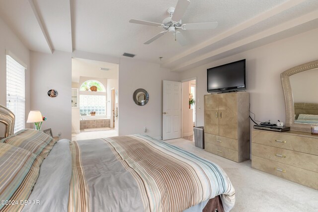 bedroom featuring ensuite bath, ceiling fan, light colored carpet, and a textured ceiling