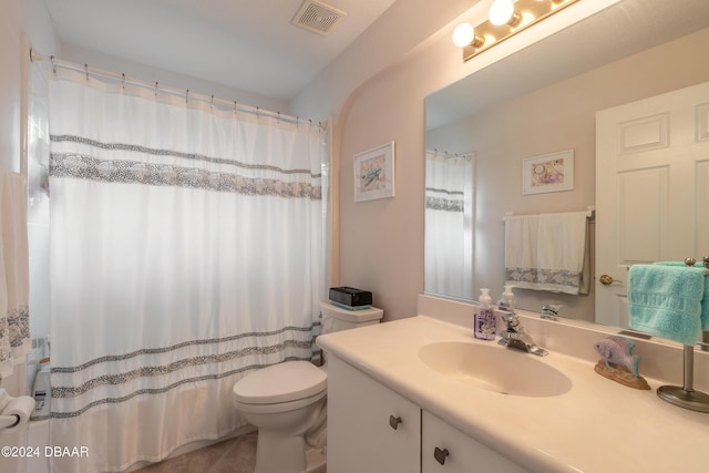 bathroom with tile patterned flooring, vanity, and toilet