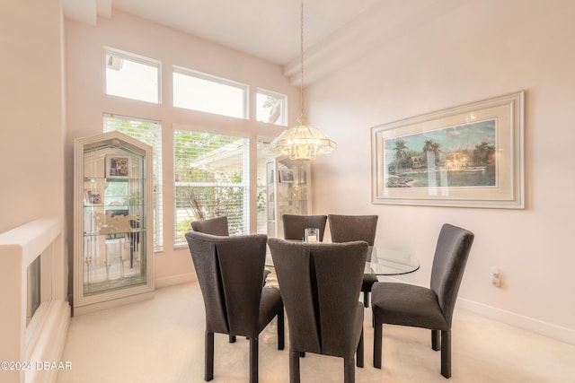 dining space featuring a notable chandelier and light carpet