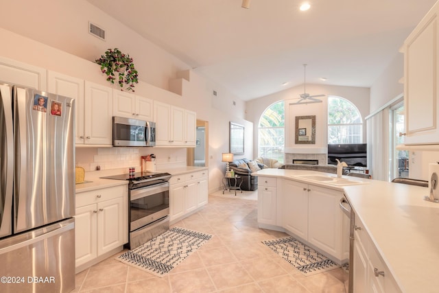 kitchen featuring white cabinetry, ceiling fan, sink, lofted ceiling, and appliances with stainless steel finishes