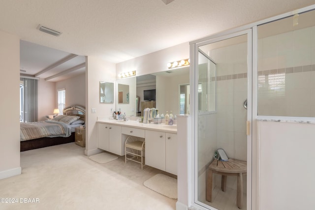 bathroom with a textured ceiling, vanity, and walk in shower