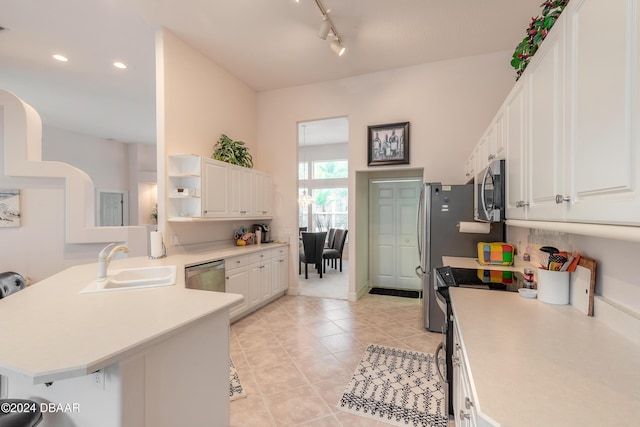 kitchen featuring white cabinets, sink, a kitchen bar, kitchen peninsula, and stainless steel appliances