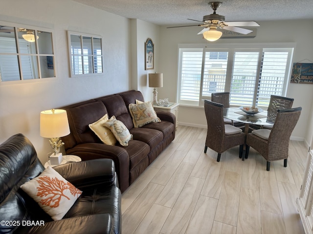 2615 S Atlantic Ave Unit 1D, Daytona Beach, FL 32118 - living room with ceiling fan, healthy amount of natural light, light wood-type flooring, a textured ceiling, and baseboards