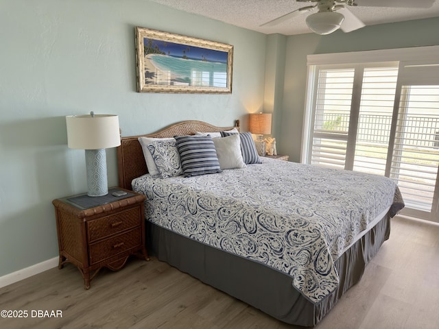 2615 S Atlantic Ave Unit 1D, Daytona Beach, FL 32118 - bedroom with light wood finished floors, multiple windows, baseboards, a textured ceiling, and ceiling fan