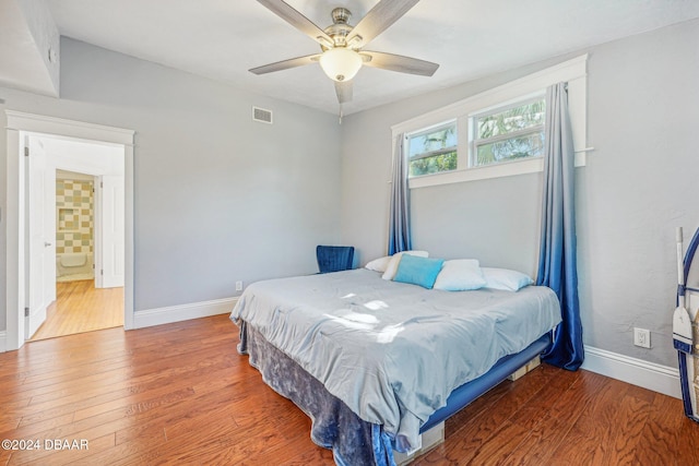 bedroom with wood-type flooring, ceiling fan, and ensuite bathroom