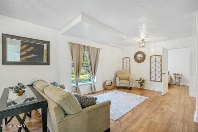 living room with a textured ceiling and light hardwood / wood-style flooring