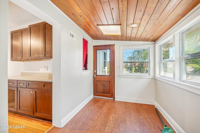 doorway to outside featuring light hardwood / wood-style flooring, lofted ceiling, and wooden ceiling