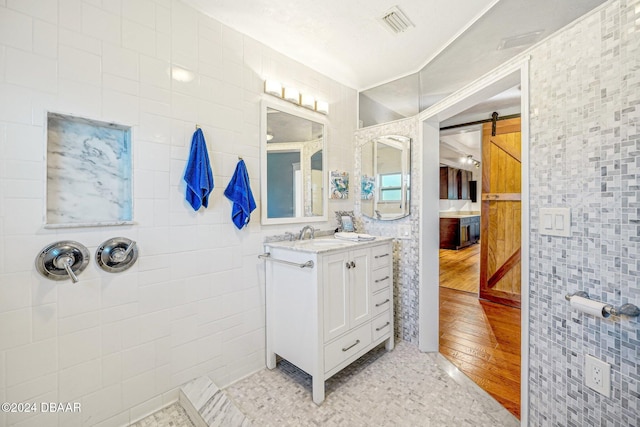 bathroom featuring tile walls, wood-type flooring, and vanity