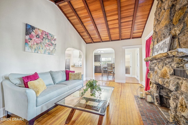 living area featuring baseboards, high vaulted ceiling, arched walkways, wood ceiling, and wood-type flooring