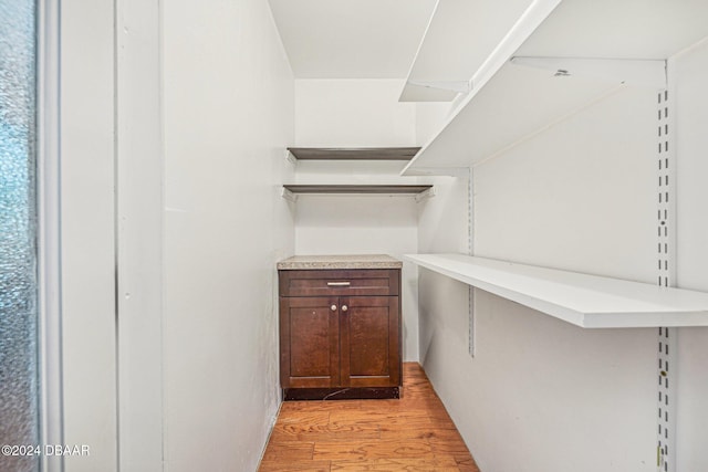 walk in closet with light wood-style flooring